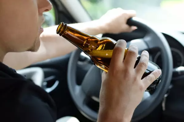 concept-alcohol-driving-crime-closeup-young-male-driver-hands-with-steering-wheel-bottle-beer