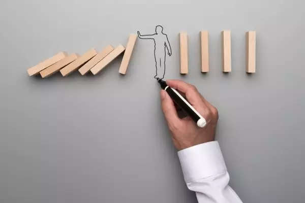 man-drawing-outline-man-stopping-domino-effect